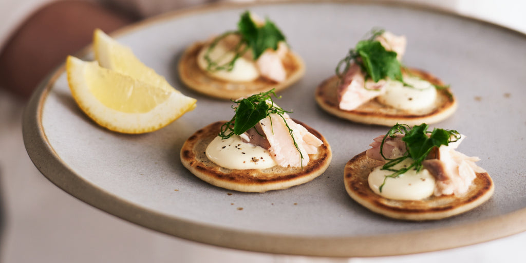 Smoked fish blinis with wasabi crème fraiche and wasabi leaves